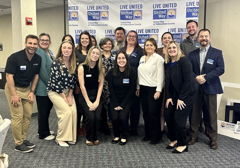 Employee Campaign Coordinators pose in front of United Way of Yellowstone County backdrop