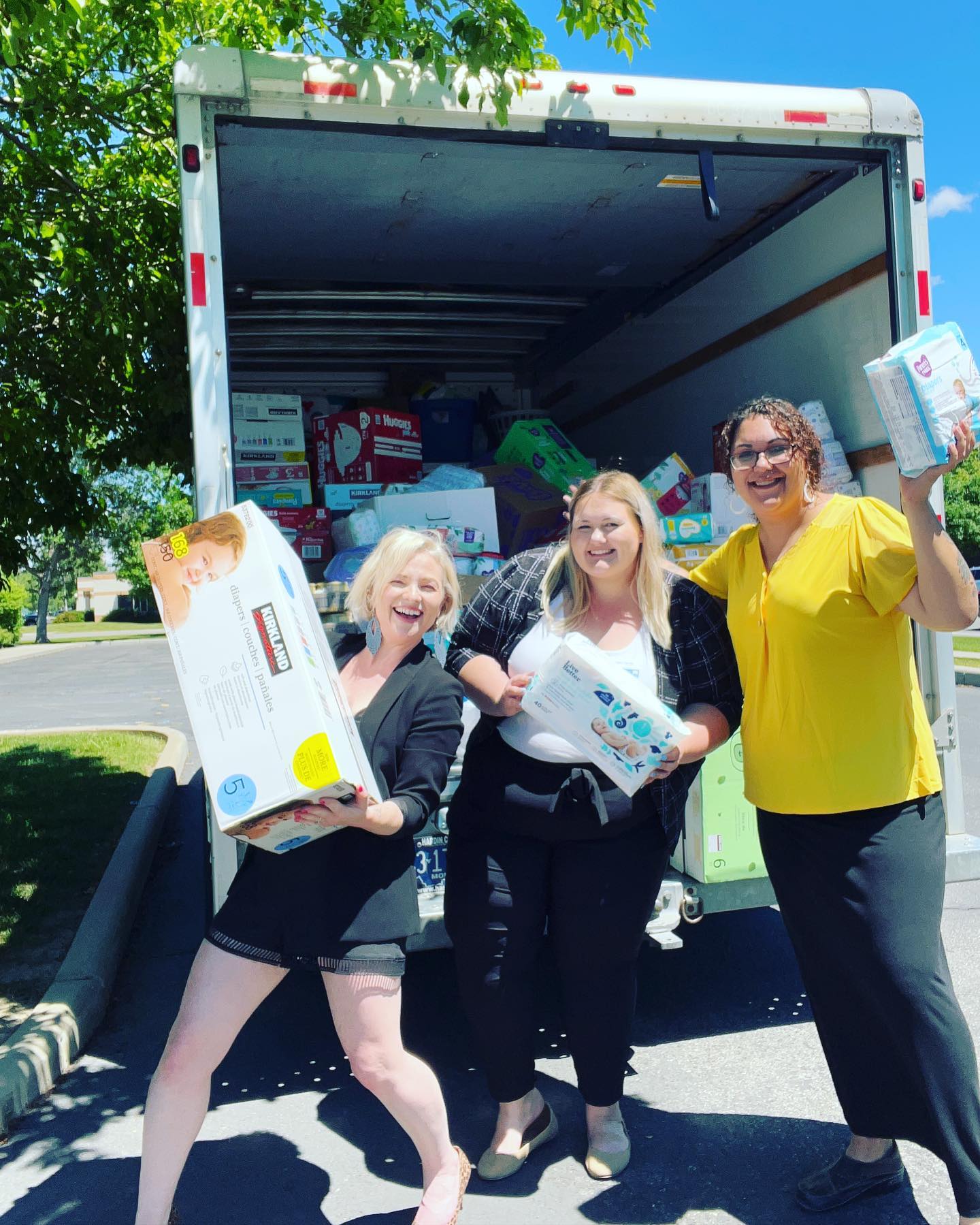 Donor poses with UWYC and Family Promise in front of diaper truck