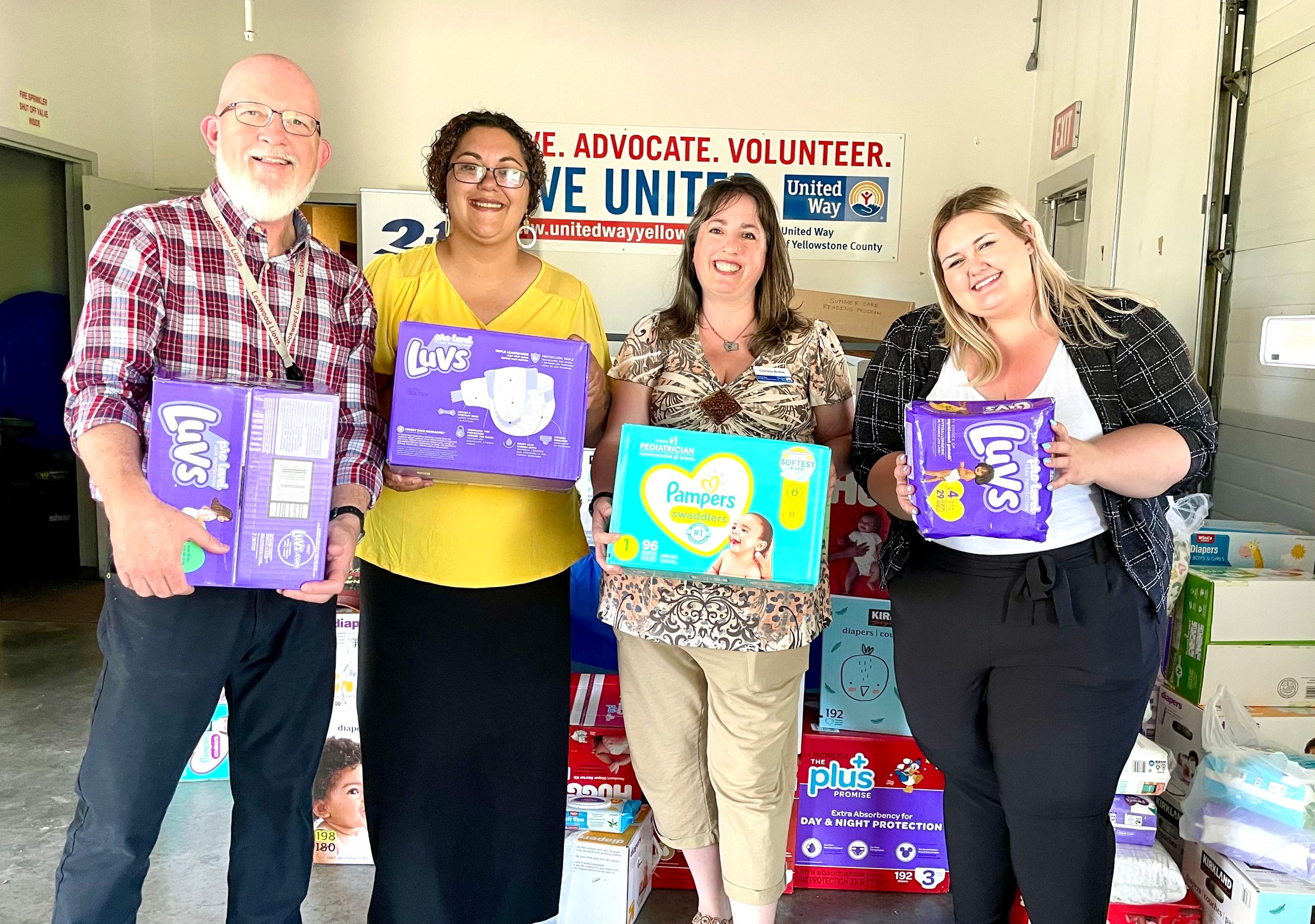 ExxonMobil's Dan Carter poses with UWYC and Family Promise staff and their donation