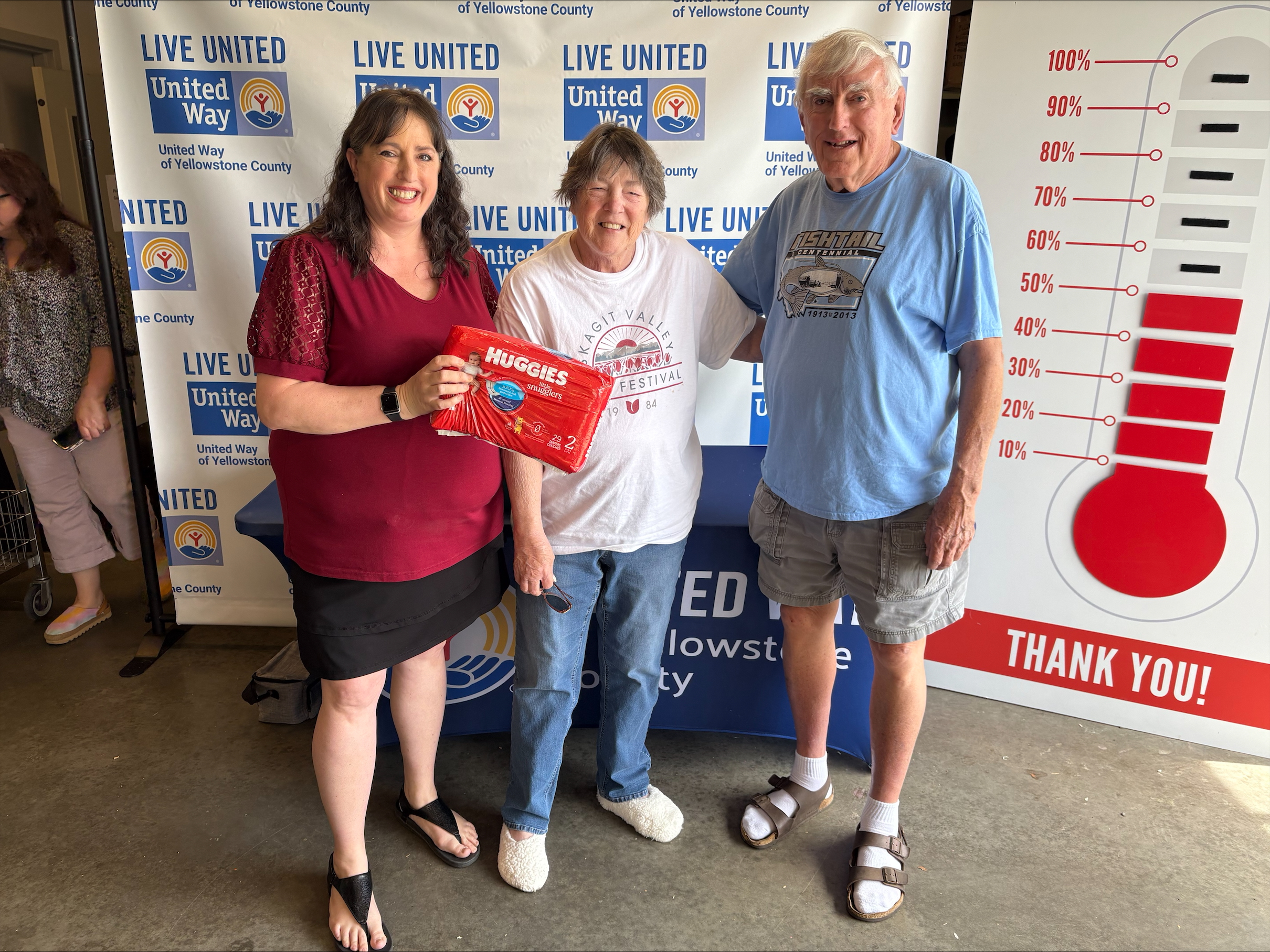 Jim and Cind Fortune pose alongside a box of donated diapers.