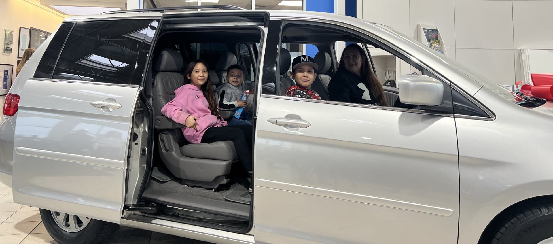 Gabby Orozco and her family site in a 2008 Honda minivan they were awarded from Underriner Motors