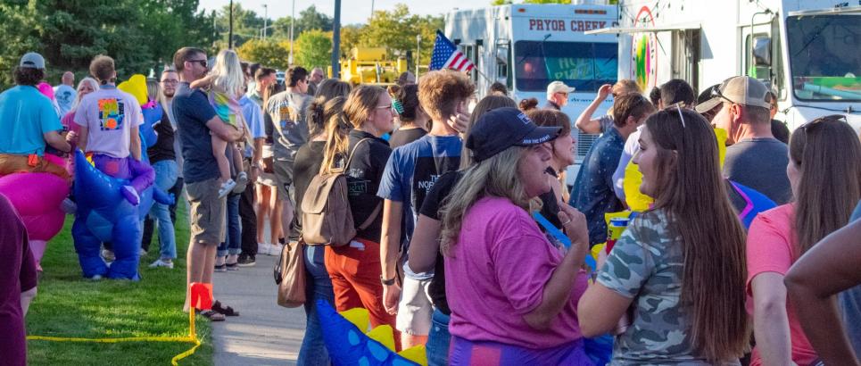 Crowds at CommUnity Rally stand near food trucks