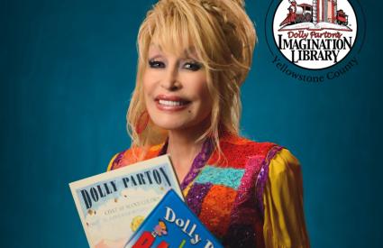Dolly Parton holds two books while smiling
