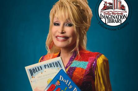 Dolly Parton holds two books while smiling