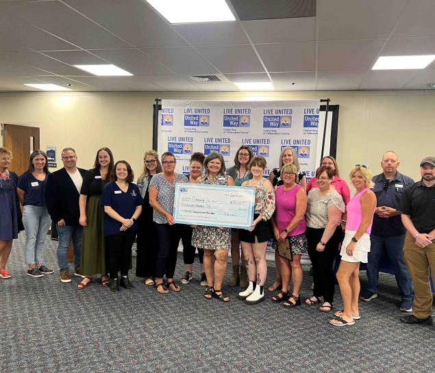 Local nonprofit leaders pose for a photo with a check for grant funding