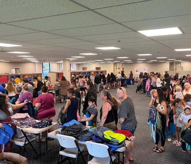 Families pack into UWYC offices to pick up school supplies and backpacks