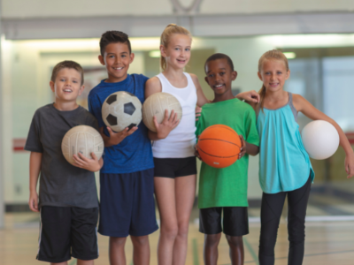 Children holding sporting equipment. 