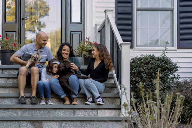 A family sits on a doorstep