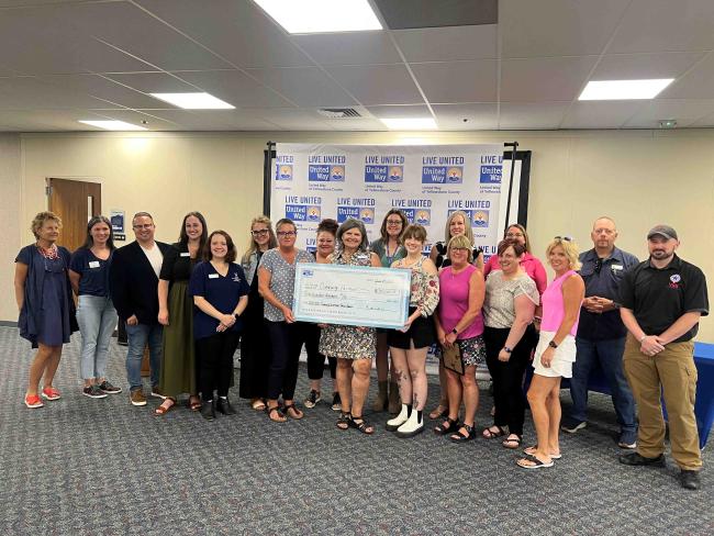 Local nonprofit leaders pose for a photo with a check for grant funding