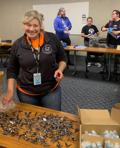 A woman smiles while volunteering with three people in the background